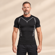 Man draagt Odelly PowerShape compressie T-shirt zwart op beige studioachtergrond